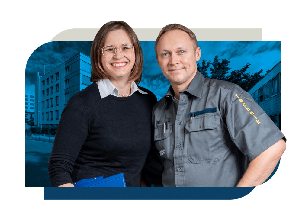 Ein Mitarbeiter in grauer Arbeitskleidung mit der Aufschrift "Technik" steht neben einer Kollegin in schwarzer Kleidung, die einen blauen Ordner hält. Beide stehen vor einem modernen Gebäude.