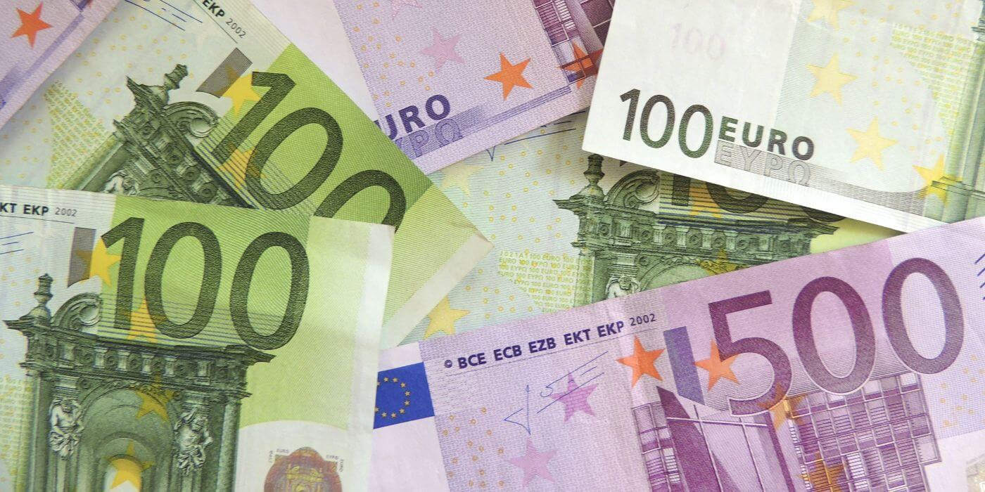 Ein Stapel von Euro-Banknoten in verschiedenen Werten, darunter 100-Euro- und 500-Euro-Scheine, als Symbol für eine attraktive Vergütung nach Tarifvertrag.