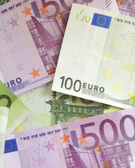 Ein Stapel von Euro-Banknoten in verschiedenen Werten, darunter 100-Euro- und 500-Euro-Scheine, als Symbol für eine attraktive Vergütung nach Tarifvertrag.