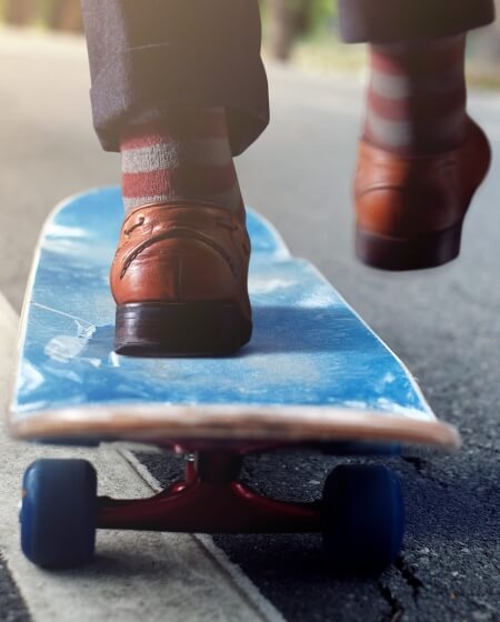 Ein Paar elegante Lederschuhe steht auf einem Skateboard, was eine kreative Verbindung von Professionalität und Freizeit symbolisiert